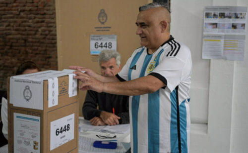 Elecciones 2023, hombre emitiendo voto ante urna