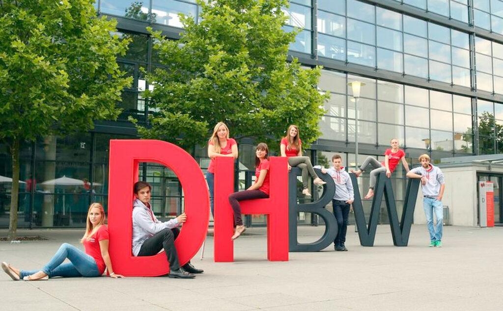 DHBW, 50º aniversario, educación dual, Universidad Estatal Cooperativa de Baden-Württemberg, Modelo educativo dual, Historia de la DHBW, Educación superior en Alemania, Baden-Württemberg, Innovación educativa, Colaboración universidad-industria, Impacto económico, Desarrollo social, Formación académica, Experiencia práctica, Digitalización en educación, Retos globales en educación, Tecnología en la educación, Estudios en economía, Investigación universitaria, Desafíos educativos futuros